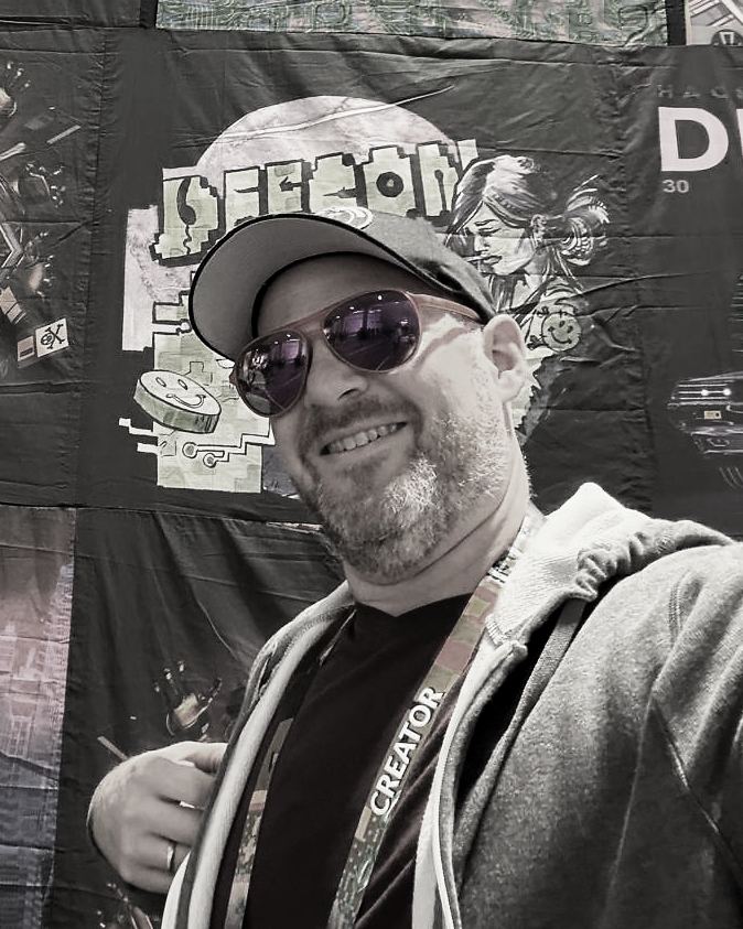 Brett Harris wearing a cap and sunglasses in front of an illustrated display